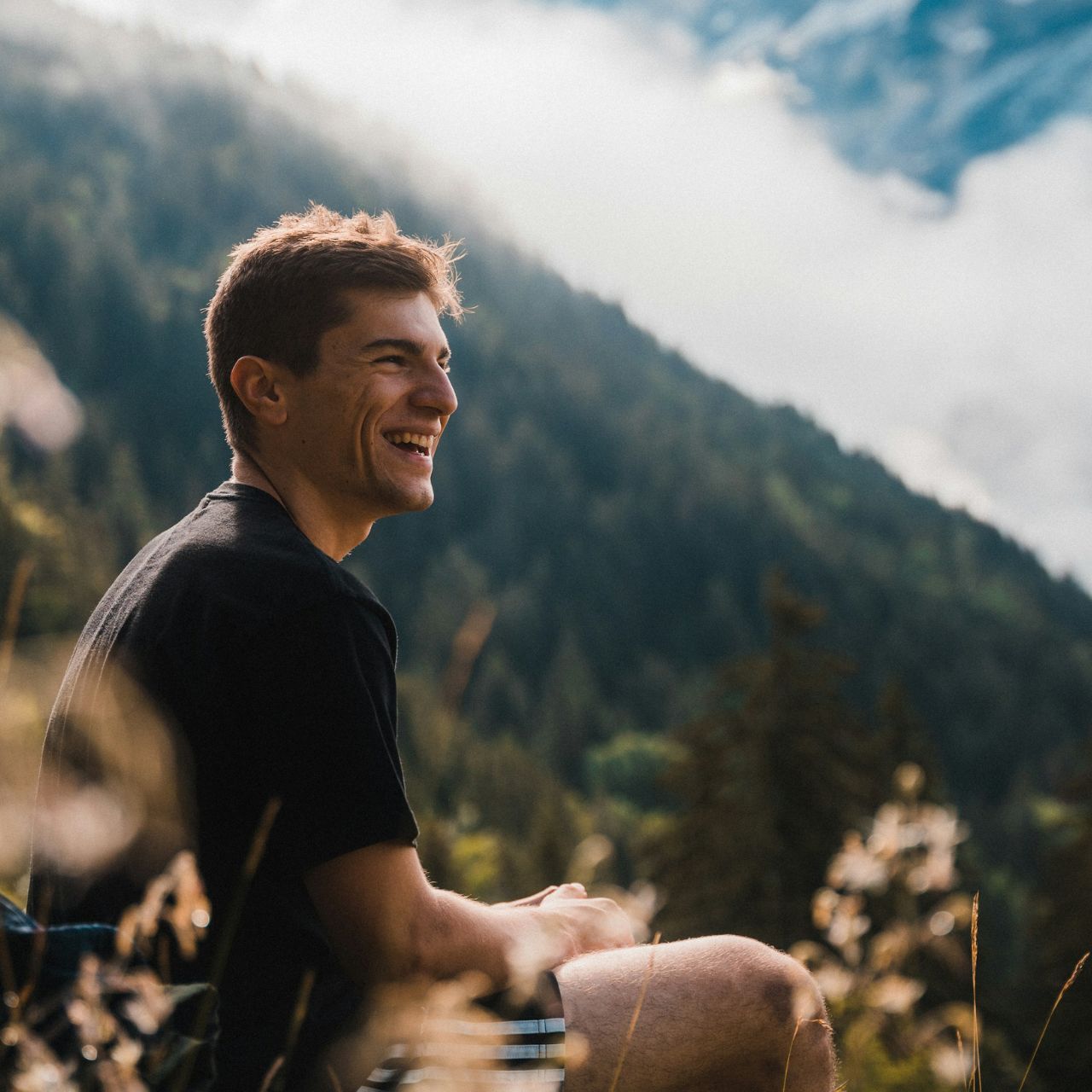 Man sitting on a hill and looking towards the horizon